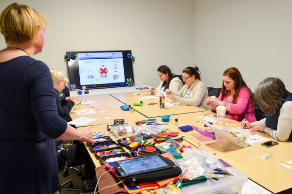 Women wiring; the team from LUND Center participates in a wearable electronics workshop with Generator member and educator Jill and learns about basic electronics.
